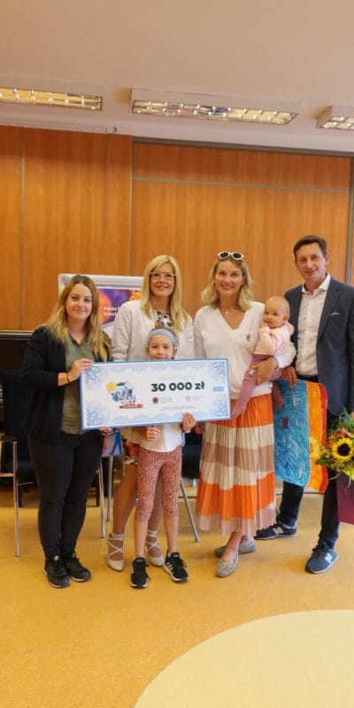 Na zdjęciu są: Prezes Fundacji Echo, zwyciężcy teleturnieju Joanna Moro i Mirosław Szpilewski oraz podopieczni Fundacji z wielkim czekiem na 30 tys. zł.