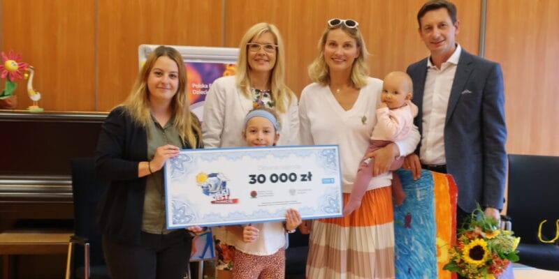 Na zdjęciu są: Prezes Fundacji Echo, zwyciężcy teleturnieju Joanna Moro i Mirosław Szpilewski oraz podopieczni Fundacji z wielkim czekiem na 30 tys. zł.